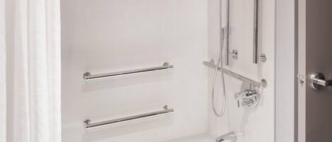 Un baño moderno con ducha a nivel, bañera y retrete.
