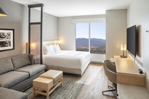 A modern hotel room with a large bed, a sofa, a desk, and a TV. - Hyatt Place Reno (Reno)