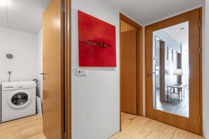 Enjoy a spacious room with a washing machine and a door leading to a dining area.