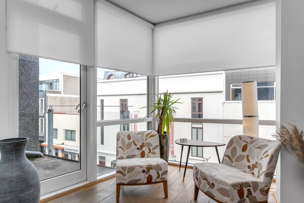 A balcony with two chairs, a small table, and a potted plant.