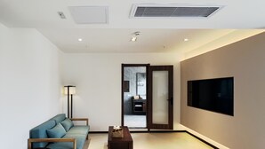 Una sala de estar moderna con un sofá, una mesa de centro y un televisor montado en la pared.