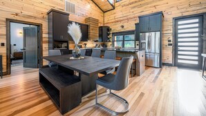 A modern kitchen with wooden walls, a central island, and stainless steel appliances. - Riverfront Modern Cabin/Pickle Ball/Slide/Shuffleboard/Outdoor Shower (Eagletown)