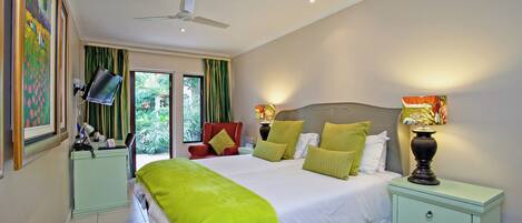 A bedroom with a bed, bedside tables, a ceiling fan, and a window with curtains.