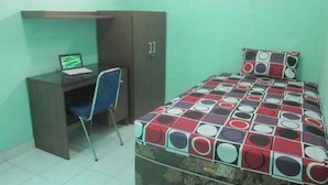 A bedroom with a bed, a desk, and a chair. - Ekost Bayeman (Sleman)