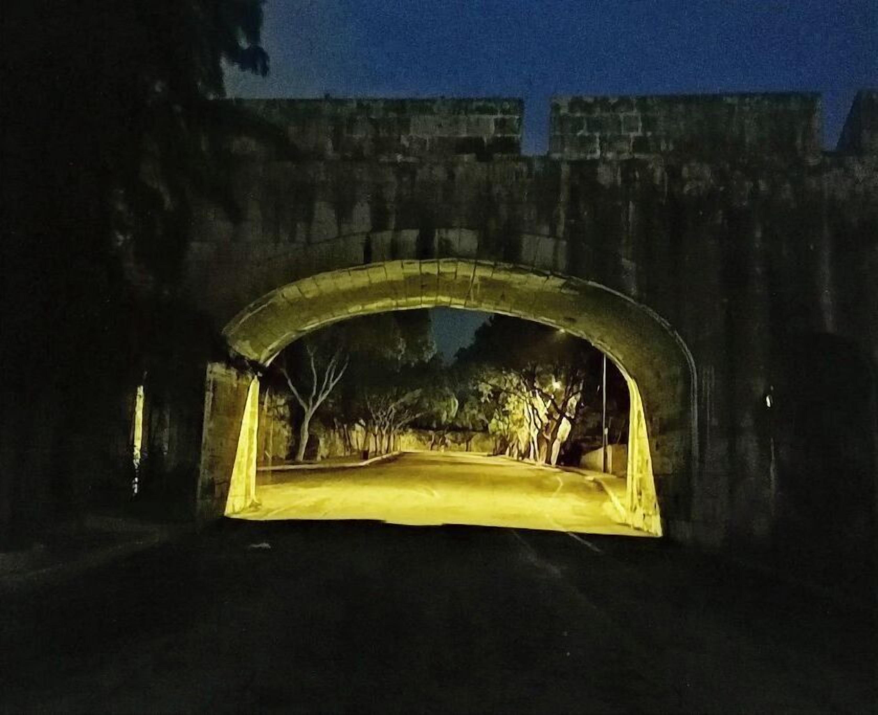 A stone bridge with a yellow-lit pathway underneath.