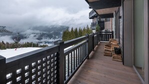 Eine Holzterrasse mit Blick auf ein Gebirge und eine Seilbahn im Hintergrund.