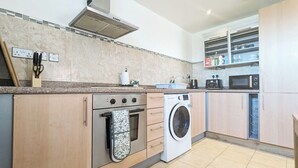 A modern kitchen with a built-in oven, microwave, and washing machine.