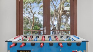 A foosball table with a view of trees through a window. - Chatby House filtered views of the ocean (Lorne)