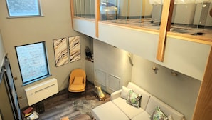 A modern living space with a sofa, a chair, a dog, and a window. - Pinnacle Suites (Cowes)