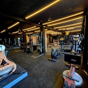 A gym with various exercise equipment, including treadmills, elliptical machines, and weight machines.