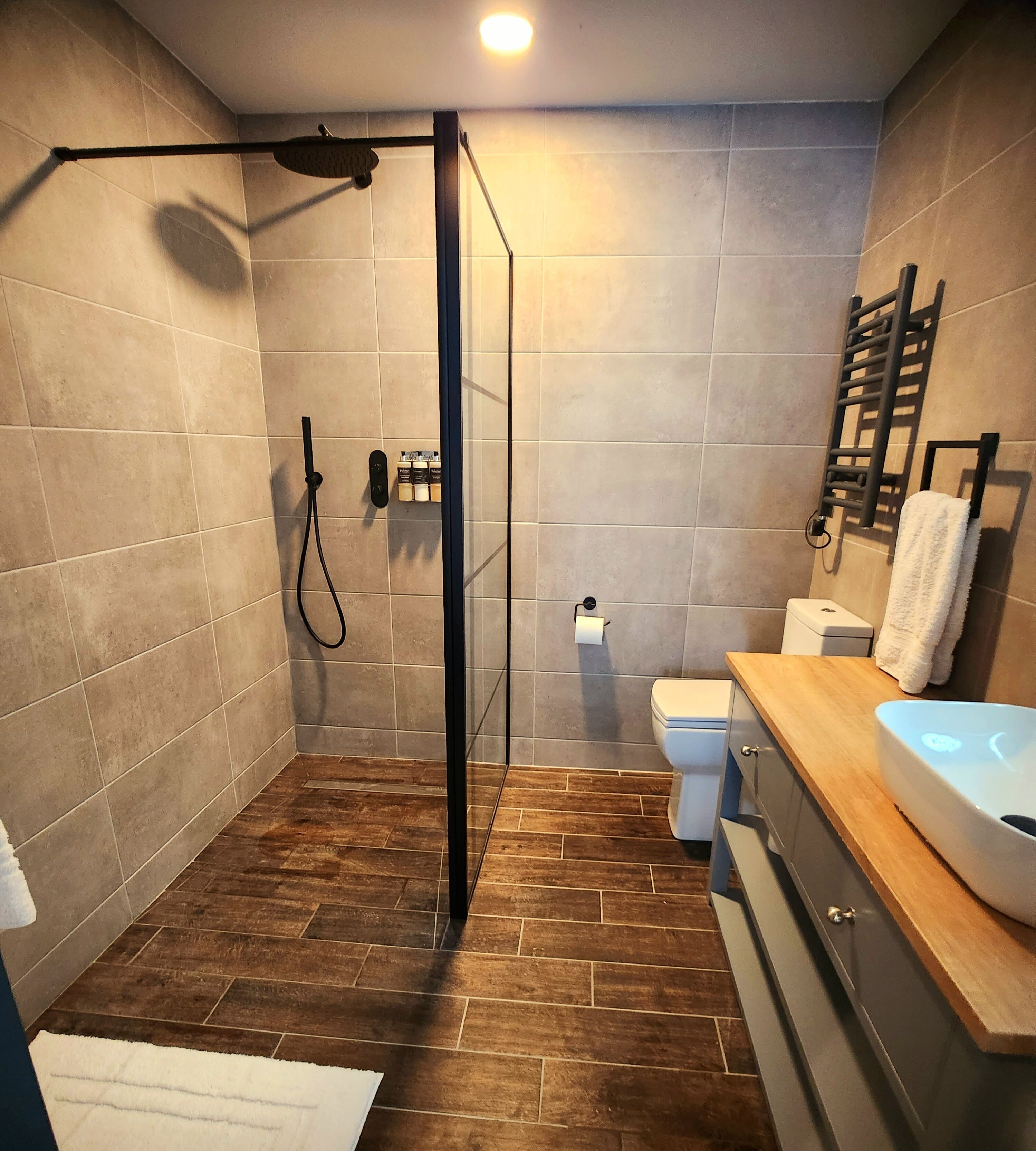 A modern bathroom with a shower, toilet, and sink.