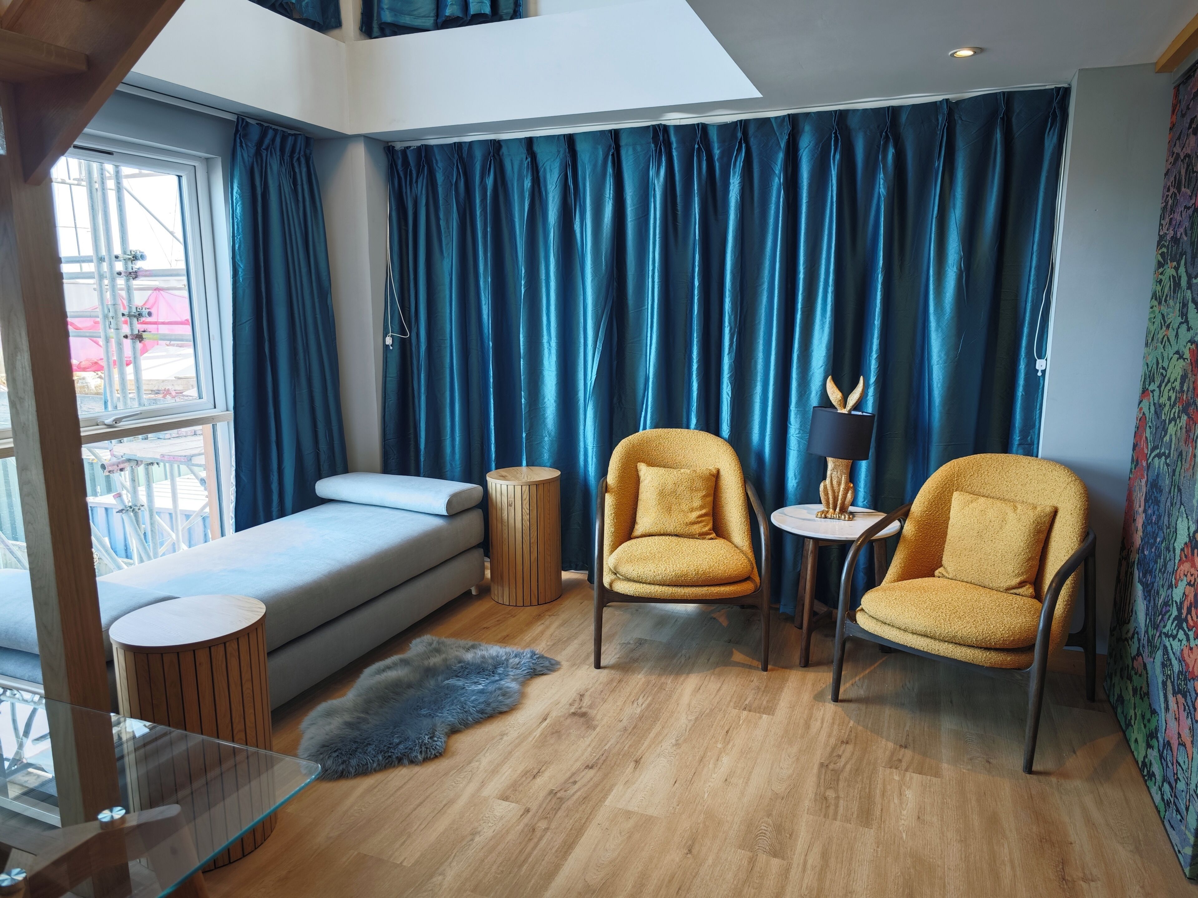 Une pièce moderne comprenant un canapé, deux fauteuils, une petite table et une table basse en verre.