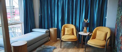 Une pièce moderne comprenant un canapé, deux fauteuils, une petite table et une table basse en verre.