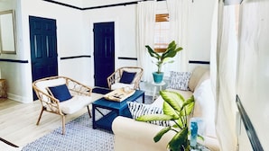 A living room with a ceiling fan, a sofa, a coffee table, and a potted plant. - Only 4 bedroom with a view of Main Street located in the Downtown Core District (Dunedin)