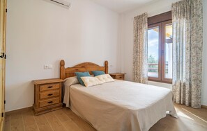 Cozy retreat with a single bed, bedside tables, and a window with floral curtains.