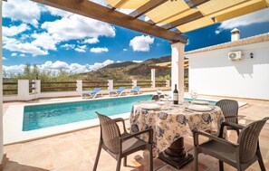 Relax by the pool with a view of the surrounding mountains, surrounded by comfortable seating and lounge chairs.