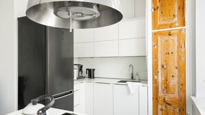 Una cocina moderna con electrodomésticos de acero inoxidable, armarios blancos y una puerta de madera.