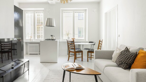 Una sala de estar moderna con sofá, mesa de centro y comedor.
