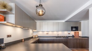 A modern kitchen with a large island, stainless steel appliances, and a pendant light. - New ski-in/ski-out duplex in Courchevel with parking (Courchevel 1850)