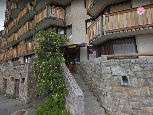 A stone staircase leading to a wooden balcony with a sign reading "Lodge".