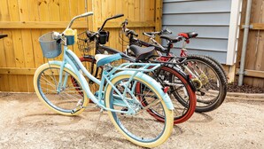 Tres bicicletas estacionadas frente a una cerca de madera.