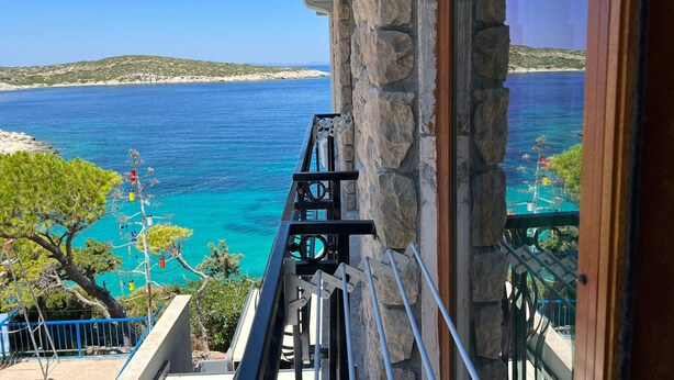 Un balcon avec un mur en pierre et une vue sur la mer.