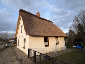 A single-story house with a thatched roof, a small porch, and a visible chimney. - Idyllic Vacation Home "Your Kingdom" (Jork)