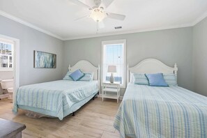 A bedroom with two beds, a ceiling fan, and a window with blinds. - Anchor Down Luxury Ocean View Beach House w Pool (North Myrtle Beach)