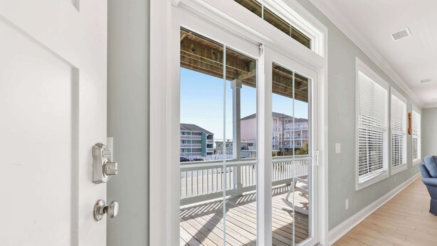Quarto com porta de correr de vidro que dá para uma varanda com deck de madeira.