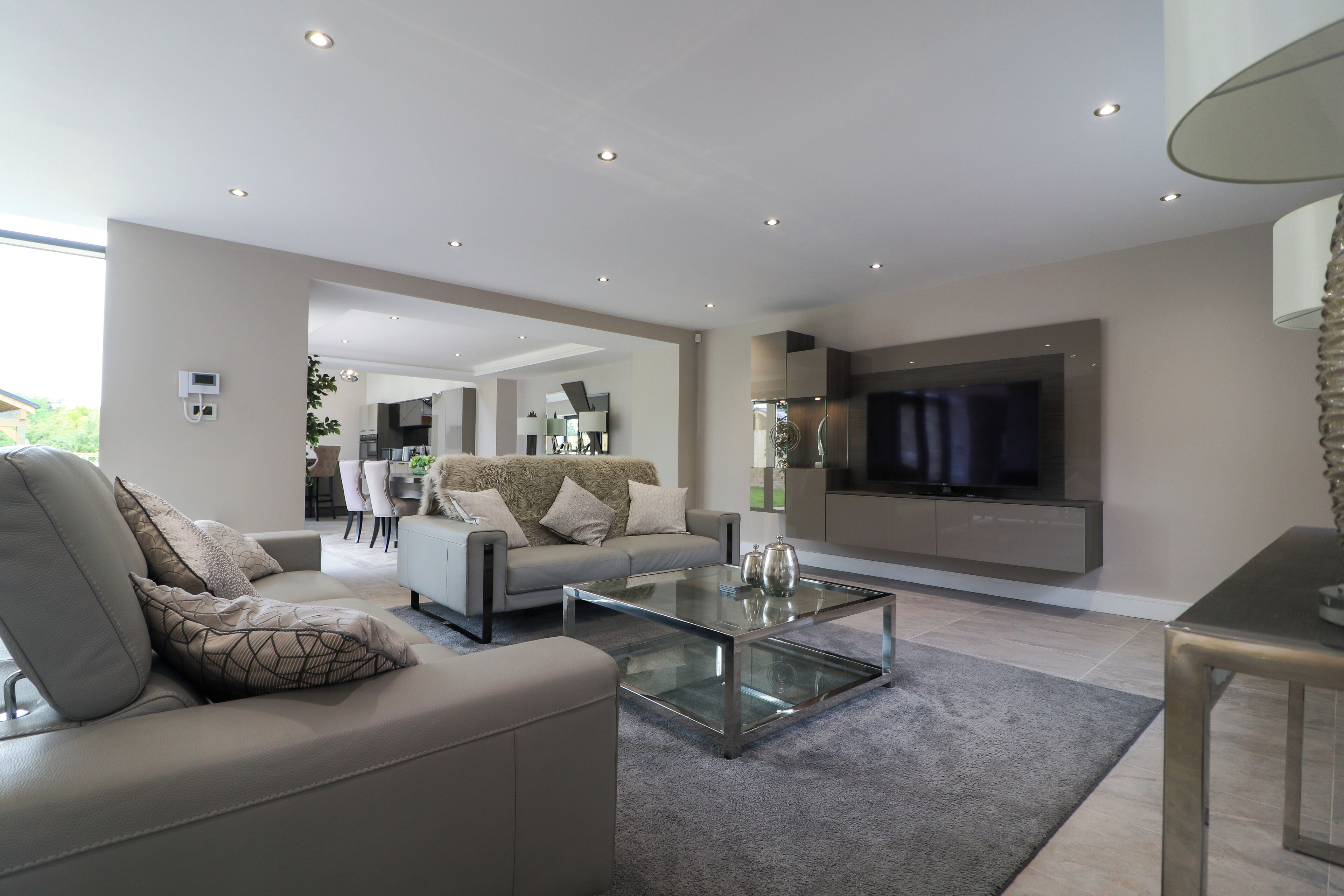 Un salon moderne avec un canapé, une table basse et un téléviseur.