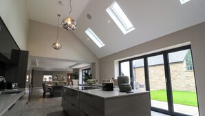 Una cocina moderna con una isla central, ventanas amplias y tragaluces.