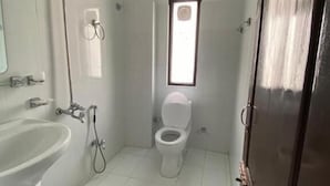 Ein kleines, sauberes Badezimmer mit Toilette, Waschbecken und Dusche.