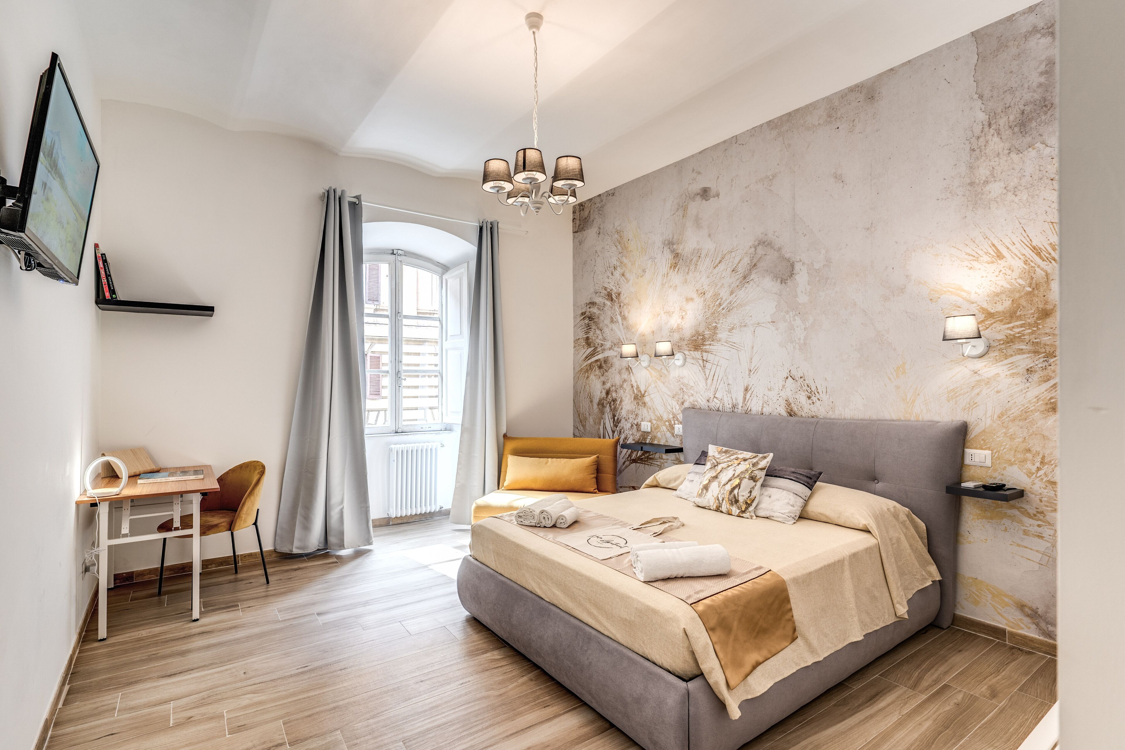 Un dormitorio moderno con una cama grande, un escritorio y un televisor.