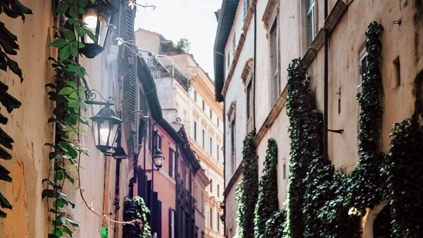 A narrow cobblestone street lined with buildings, some with ivy. There are two scooters parked on the street. - New apartment in center of Rome, 300mt from the metro stop and train station (Roma)