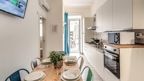 A modern kitchen with white cabinets, a microwave, and an oven. - New apartment in center of Rome, 300mt from the metro stop and train station (Roma)