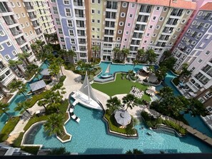 A multi-story hotel with a central swimming pool surrounded by palm trees and lounge areas. - Seven Seas Côte d'Azur by PSR (Sattahip)