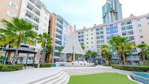 A modern hotel with a central courtyard featuring a boat, palm trees, and a pool. - Seven Seas Côte d'Azur by PSR (Sattahip)