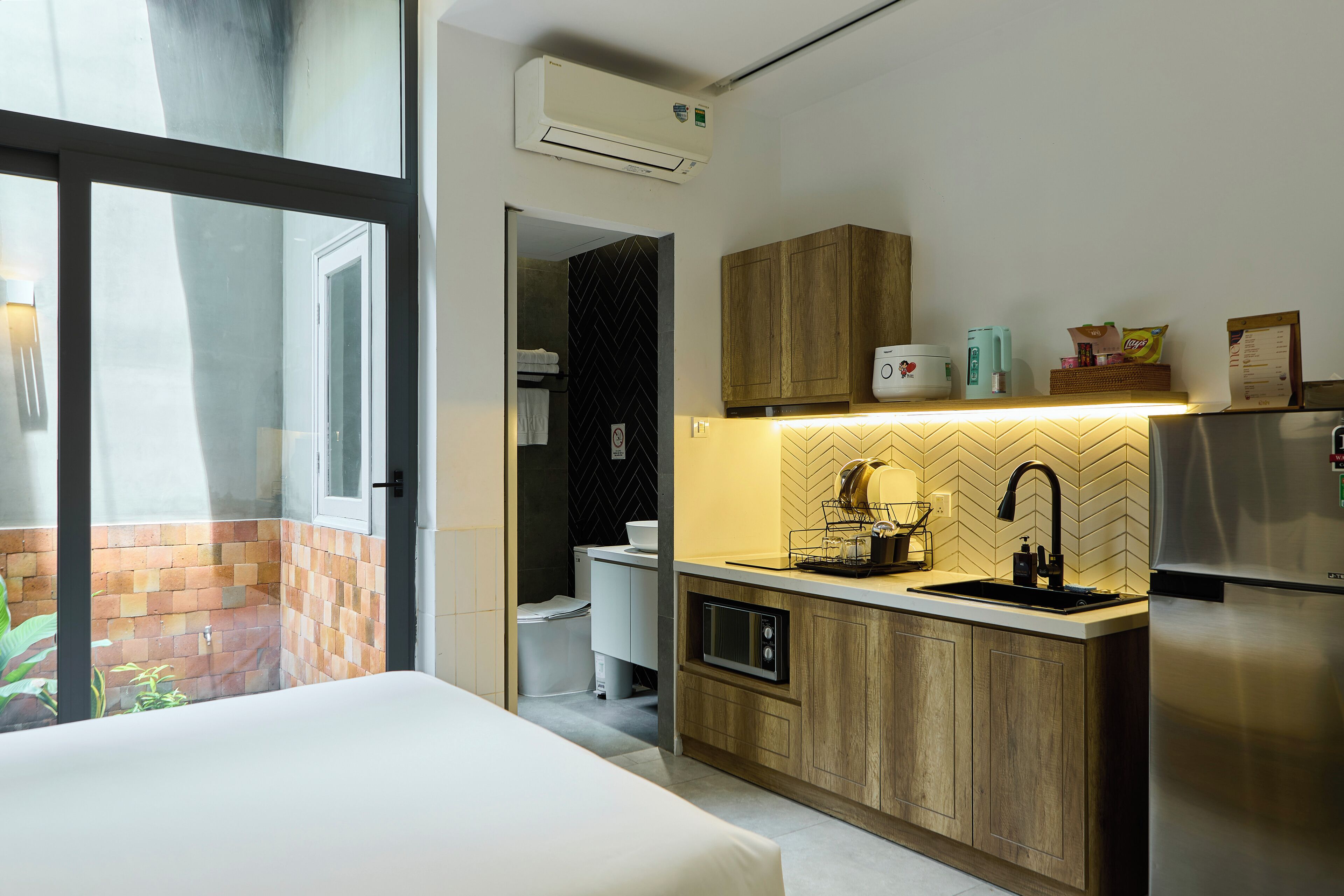 Una cocina moderna con horno empotrado, refrigerador y lavamanos.