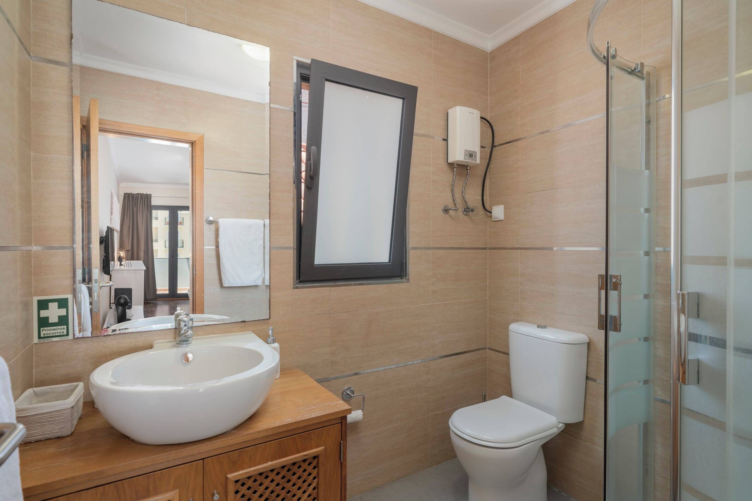 Un bagno moderno con un lavandino ampio, un water e uno spazio doccia in vetro.