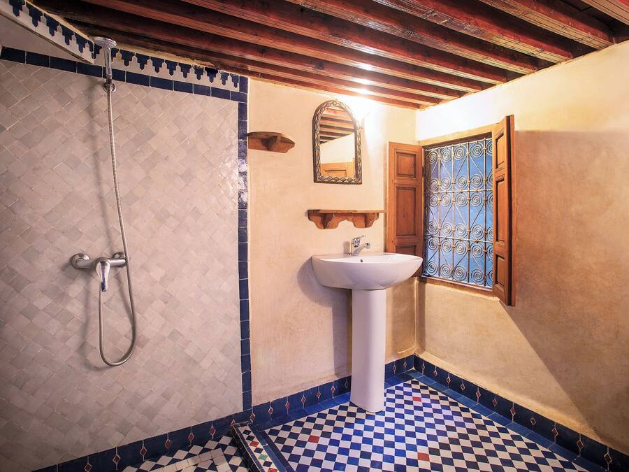A bathroom with a shower, a sink, and a mirror.