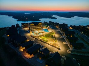 An aerial view of a resort with a swimming pool, multiple buildings, and a parking area. - Pools! Hot Tub, Fire Pit, Game Room, Fun for Families and Groups! (Kimberling City)