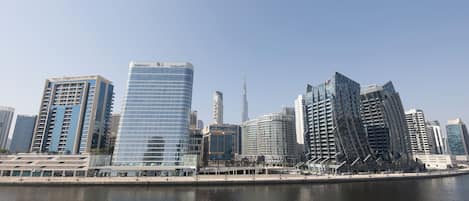 A city skyline with modern high-rise buildings, a prominent tower, and a waterfront.