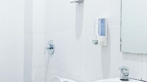 Un baño con inodoro, lavamanos y espejo.