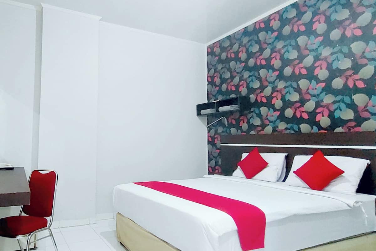 Hotellihuone, jossa on sänky, työpöytä ja tuoli.