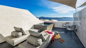 Terraço no telhado com sofá, cadeiras, mesa e banheira de hidromassagem.