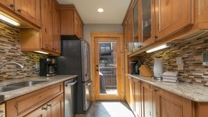 Una cocina con armarios de madera, un refrigerador de acero inoxidable y salpicadero de azulejos.