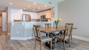A modern kitchen with white cabinets, stainless steel appliances, and a central island with seating.