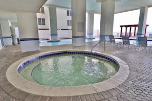 A hot tub area with a pool, lounge chairs, and a 'No Diving' sign.