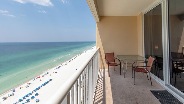 A balcony with a clear view of a beach and ocean.