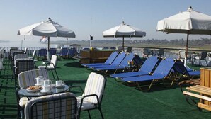 A rooftop lounge area with lounge chairs, umbrellas, and tables. - JAZ Helio Nile Cruise - Every Monday from Luxor for 07 & 04 Nights - Every Friday From Aswan for 03 Nights (Luxor)